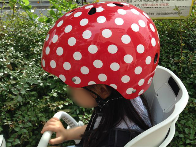「ナットケース（NATCASE）」子供用自転車ヘルメット（シミミニドッツ）を子供が装着している様子。横から撮影