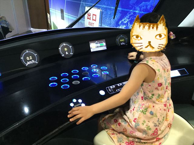 「カワサキワールド」路面電車SWIMOの運転席に座る娘