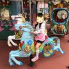 神戸王子動物園遊園地「メリーゴーランド」の馬に乗る娘