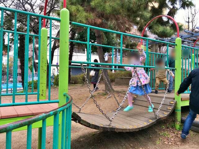 東高津公園の複合遊具の橋を渡る子供