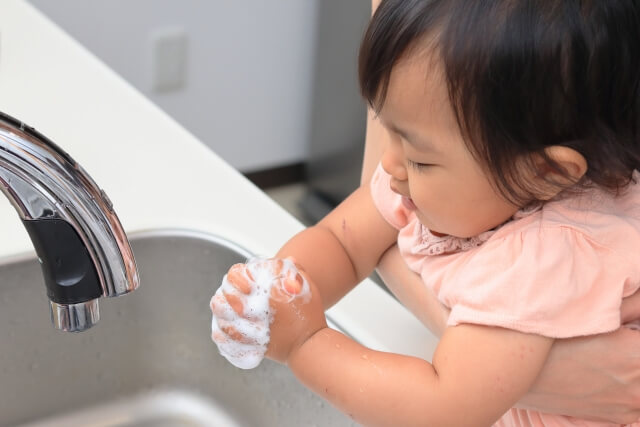 2歳の子供が洗面所で手洗いをしている